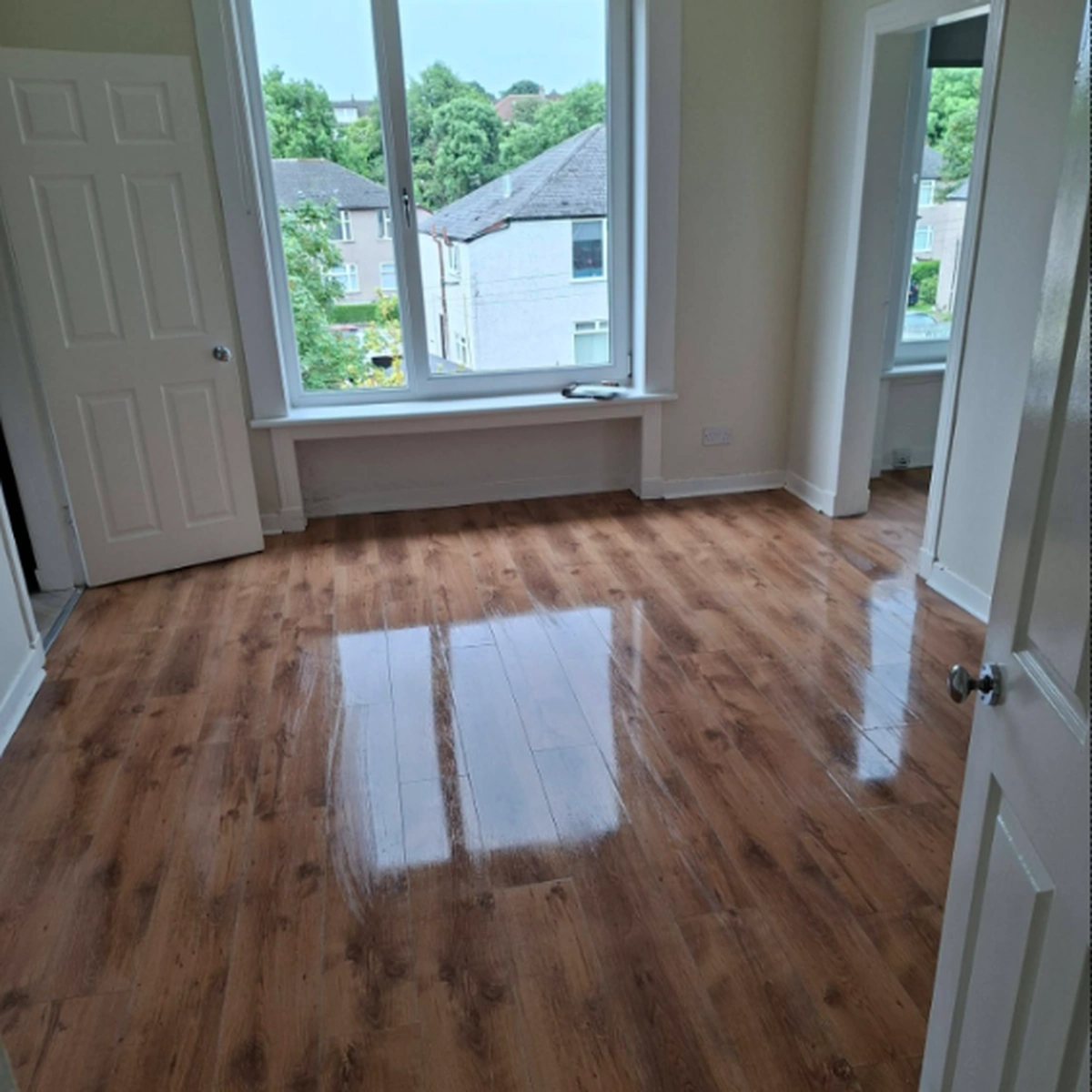 Freshly cleaned polished floor in a bright empty room